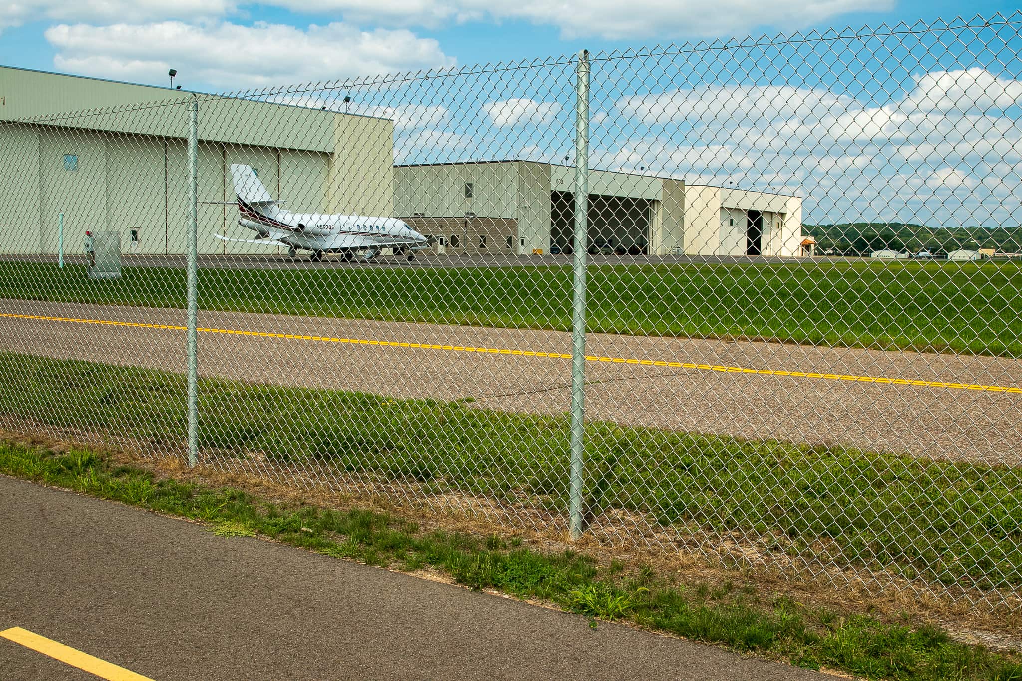Many well-known local corporations have planes based at St. Paul Downtown Airport. A corporate or charter jet sits on the tarmac awaiting its next flight. The road in the foreground is the private section of Eaton Street within the airport property.