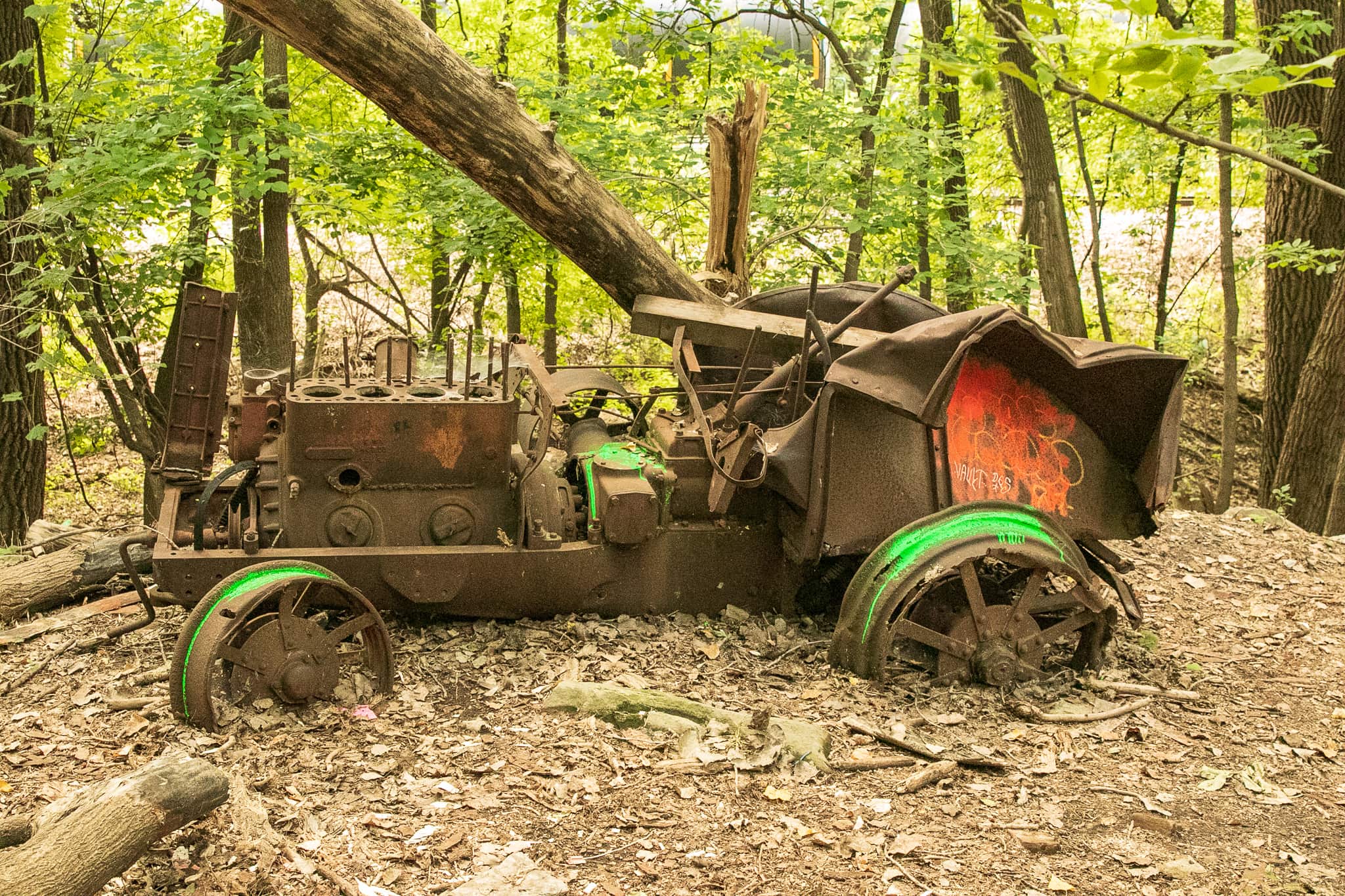 An unexpected relic, the rusting carcass of a vehicle - perhaps a tractor - sits just off the trail.