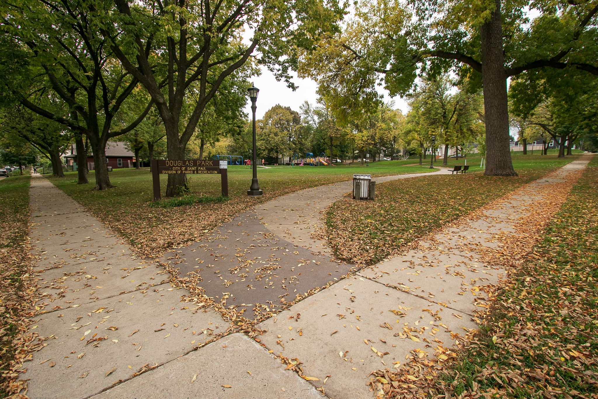 The northwest gateway into Douglas Park. The sidewalk to the right parallels Orleans Street and the sidewalk on the right is next to Stevens Street.